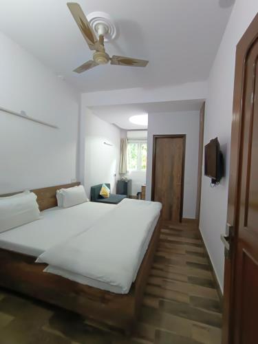 a bedroom with a bed and a ceiling fan at Tatvamasi Homestay in New Delhi