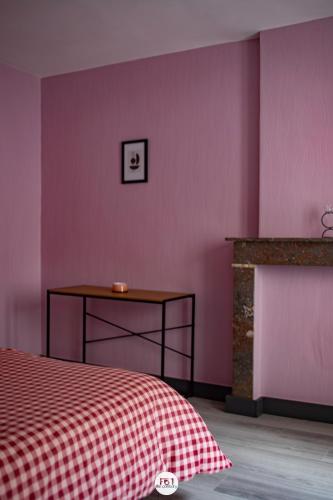 a bedroom with a bed and a table and a wall at Résidence des Chartriers in Mons