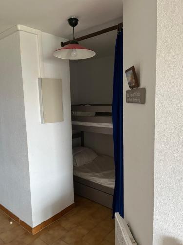 Cette chambre comprend un placard avec un lit et une lampe. dans l'établissement 34300 le cap d’Agde, au Cap d'Agde
