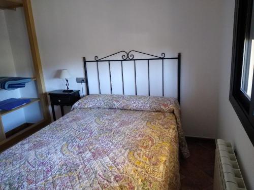a bed in a bedroom with a bedspread on it at Casa rural los Cuartos in San Benito de la Contienda