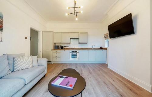 a living room with a couch and a table at Freshly decorated apartment 10 mins from Cotswolds Child Friendly Great location with plenty of nearby free parking freestanding bath and outdoor private terrace area in Evesham