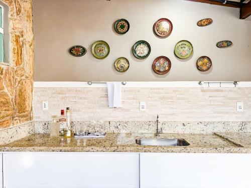 a kitchen with plates on the wall and a sink at Casarão e piscina localização excelente | ROSF91 in Rio das Ostras