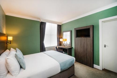 a hotel room with a bed and a television at Bromley Court Hotel London in Bromley
