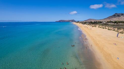 an overhead view of a beach with people in the water at Casa da Palmeira by An Island Apart in Porto Santo
