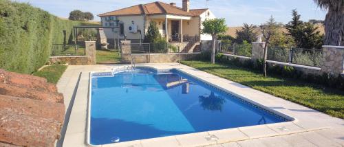 a swimming pool in the backyard of a house at Casa rural los Cuartos in San Benito de la Contienda