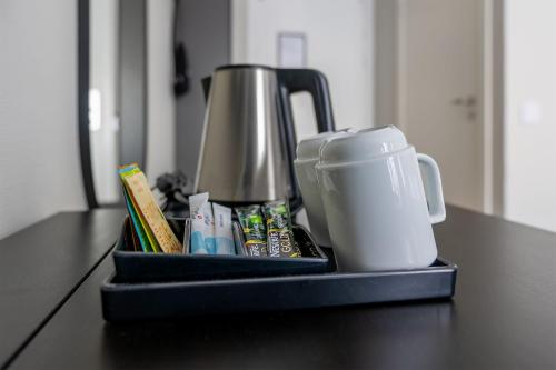 a tray with a coffee maker and a cup on a counter at Hotel Statt Söderhamn by First Hotels in Söderhamn