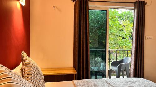 a bedroom with a bed and a window at Arize You Homes Anjuna in Anjuna