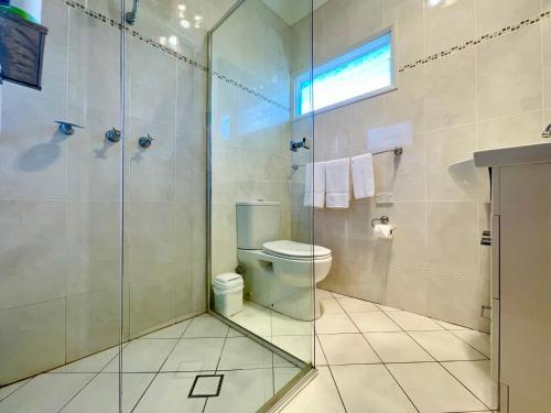a bathroom with a toilet and a glass shower at Scarlett's Place in Blackheath