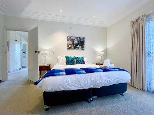 a bedroom with a large bed with blue and white sheets at Scarlett's Place in Blackheath