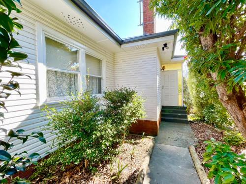 a white house with a pathway leading to the front door at Scarlett's Place in Blackheath