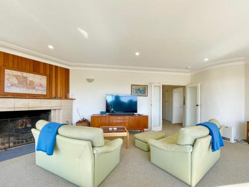 a living room with two couches and a tv at Scarlett's Place in Blackheath