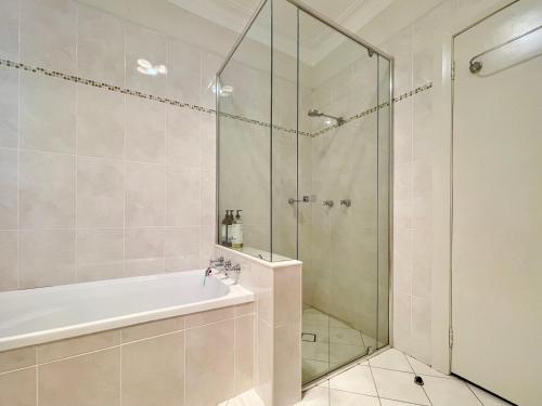 a bathroom with a tub and a glass shower at Scarlett's Place in Blackheath