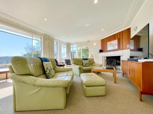 a living room with two couches and a fireplace at Scarlett's Place in Blackheath