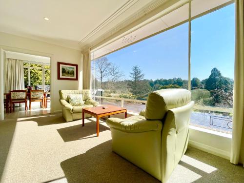 a living room with two chairs and a large window at Scarlett's Place in Blackheath