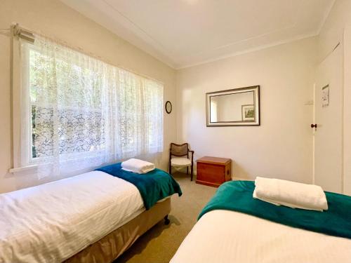 a bedroom with two beds and a window at Scarlett's Place in Blackheath