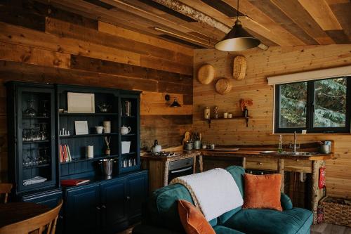 a kitchen with wooden walls and a blue couch in a room at Old Oak Farm in Oakham