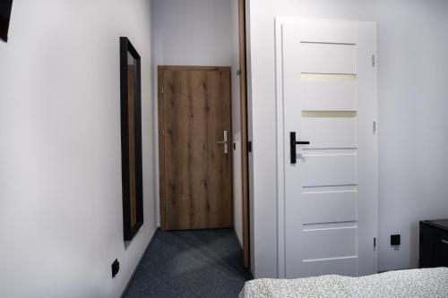 a bedroom with a white door and a wooden closet at Dream Aparts - Wschodnia 34 in Łódź