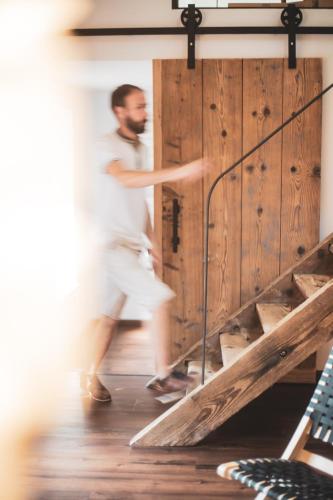 un homme se tient devant une porte en bois dans l'établissement Domaine du Pré-Saint-Georges, à Taintrux