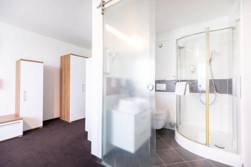 a bathroom with a shower and a toilet at Hotel Aviva in Leipzig