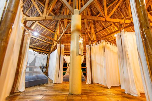 a large room with white curtains in a building at Water to Forest Ecolodge in Loboc