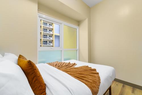 a bedroom with a bed and a window at Luxury Condo Ocean View 1,2,3, & 4 Bedrooms Infinity Pool Gym Spa Next to Okada Solaire MOA NAIA Airport in Manila