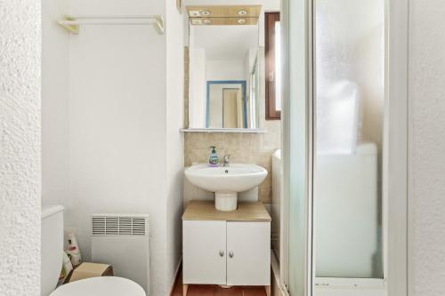 a small bathroom with a sink and a mirror at Appartement Chêne Liège in Sainte-Maxime
