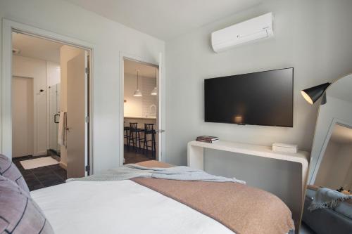 a bedroom with a bed with a flat screen tv on the wall at Luxury Apartments by Hyatus at The Asher in Stamford