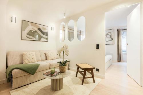 un salon avec un canapé et une table dans l'établissement Opéra - Elégant appartement - Haystia, à Paris