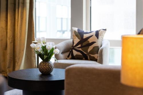 a vase of flowers on a table in a living room at Luxury Apartments by Hyatus at The Asher in Stamford