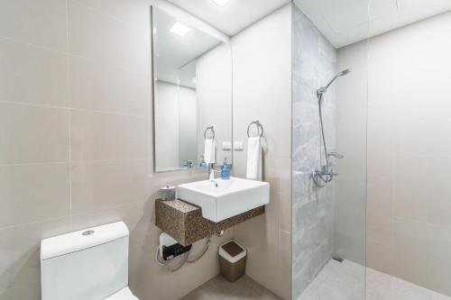 a bathroom with a sink and a toilet and a mirror at Luxury Condo Ocean View 1,2,3, & 4 Bedrooms Infinity Pool Gym Spa Next to Okada Solaire MOA NAIA Airport in Manila