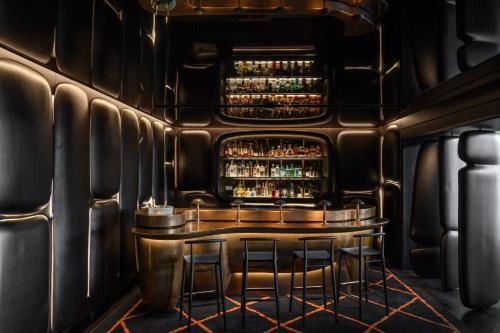a bar in a nightclub with bar stools at The Dolder Grand - City and Spa Resort Zurich in Zürich
