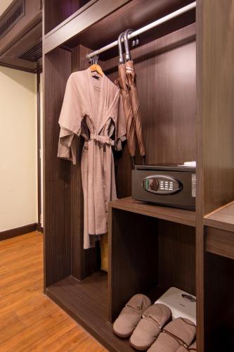a walk in closet with a robe and a radio at Princess Kamala Beachfront Hotel in Kamala Beach