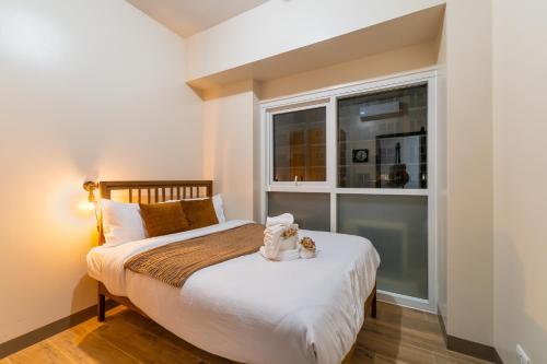 a bedroom with a bed with a window at Luxury Condo Ocean View 1,2,3, & 4 Bedrooms Infinity Pool Gym Spa Next to Okada Solaire MOA NAIA Airport in Manila
