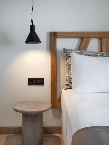 a bedroom with a bed and a stool next to a table at Klοstrá in Foinikiá