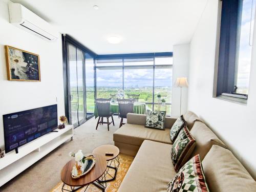 a living room with a couch and a table at Cozy Apt w Park View by Stadiums in Sydney