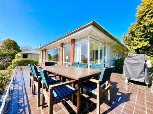 a wooden table and chairs on a patio at Scarlett's Place in Blackheath