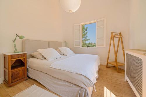 Un dormitorio blanco con una cama y una ventana. en For Me Formidable, en Roussillon