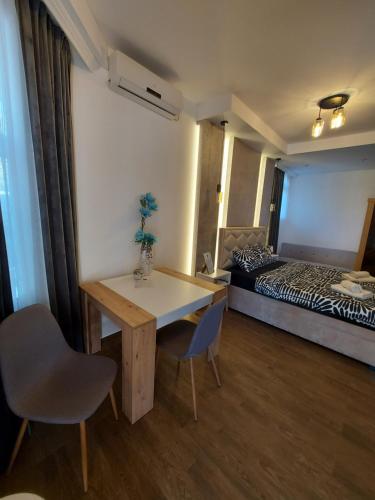 a room with a table and chairs and a bed at Stan na dan PREMIUM 1 Obrenovac in Obrenovac