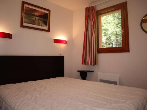 une chambre avec un lit blanc et une fenêtre dans l'établissement Appartement standing aux Orres 1800 avec piscine, sauna, hammam, wifi, animaux admis - FR-1-322-32, aux Orres