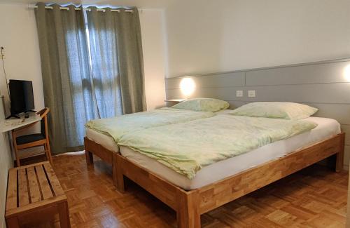 a bedroom with a large bed and a television at Le Relais de la Croisée in Malvilliers