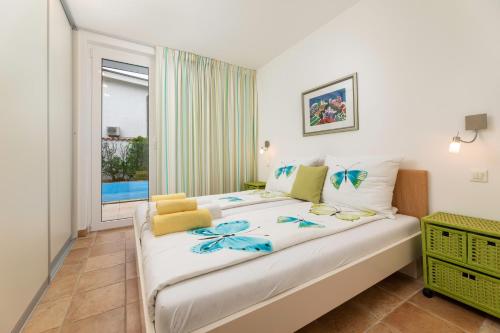 a bedroom with a large bed with a window at Apartman Fana in Njivice