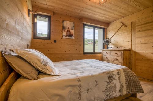 a bedroom with a bed in a wooden cabin at l'écureuil, chez le charpentier d'antan, la chaleur du bois, le calme de la campagne in Epagny Metz-Tessy