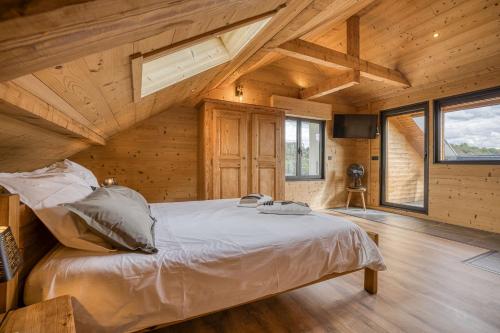 a bedroom with a bed in a wooden house at l'écureuil, chez le charpentier d'antan, la chaleur du bois, le calme de la campagne in Epagny Metz-Tessy