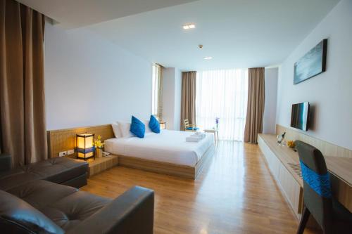 una habitación de hotel con una cama y un sofá en Grand Vista Hotel Chiangrai, en Chiang Rai