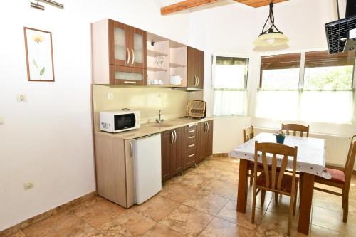 a kitchen with a table and a microwave at Complex Perpera in Stambolovo