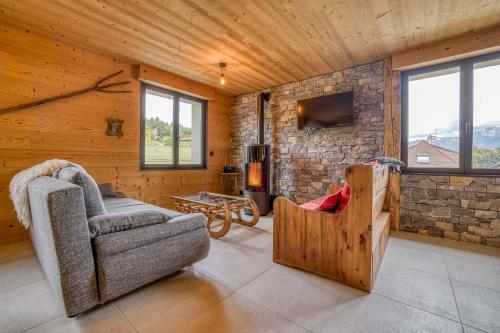 a living room with a couch and a stone wall at l'écureuil, chez le charpentier d'antan, la chaleur du bois, le calme de la campagne in Epagny Metz-Tessy