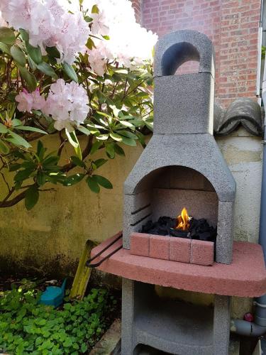 - un four en pierre installé sur un banc dans un jardin dans l'établissement L'Estivale maison cosy avec véranda et climatisation, à Étretat