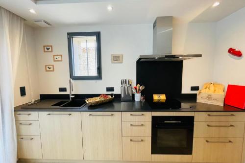 - une cuisine avec un comptoir noir et un réfrigérateur noir dans l'établissement La Vie Joly, à Gordes