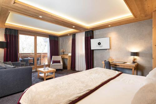 a hotel room with a bed and a living room at Le Kaïla in Méribel