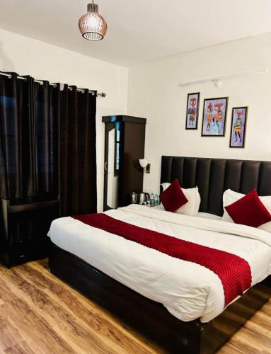 a bedroom with a large bed with red pillows at The Boho Heritage Woods in Nainital